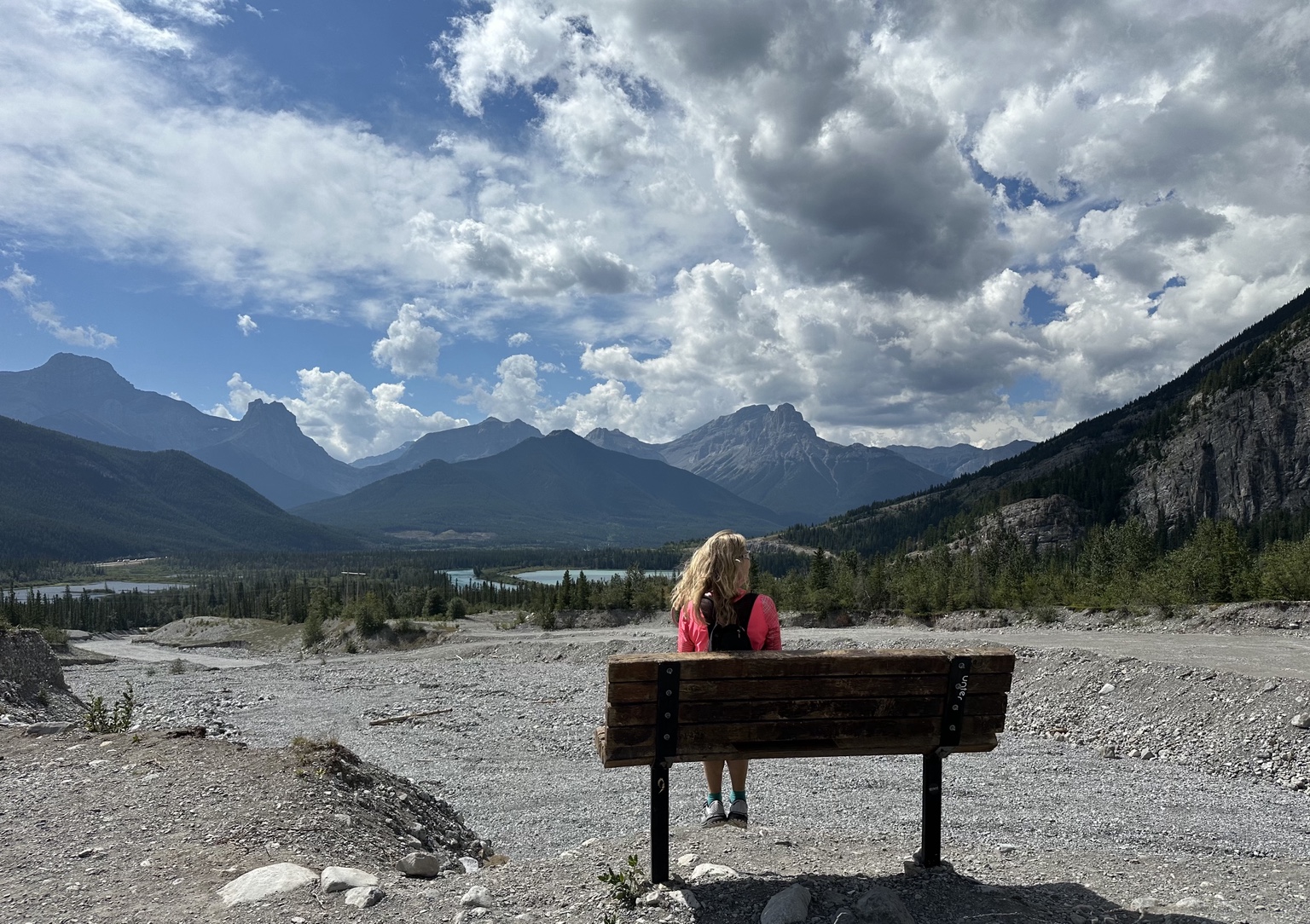 Jayne sitting on a bench and enjoying an Alberta mountain view